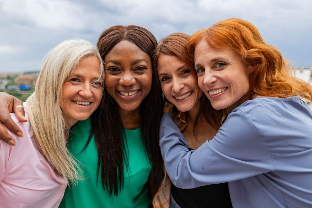 Four older women smiling