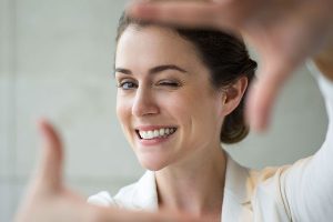 Middle-aged woman miming taking a picture of herself